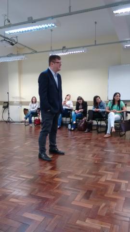 A interação entre colegas e a ligação entre a qualidade do ambiente de trabalho e a produtividade são alguns dos tópicos da capacitação (Crédito: Carlos Aranda) A imagem mostra o professo César em pé, falando com a turma. ao fundo, servidores estão sentados e olhando para o professor.